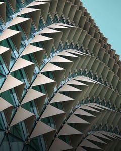 A modern building featuring numerous triangular windows, creating a unique architectural design.
